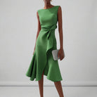 Green dress with a bow detail on a plain background