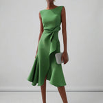 Green dress with a bow detail on a plain background