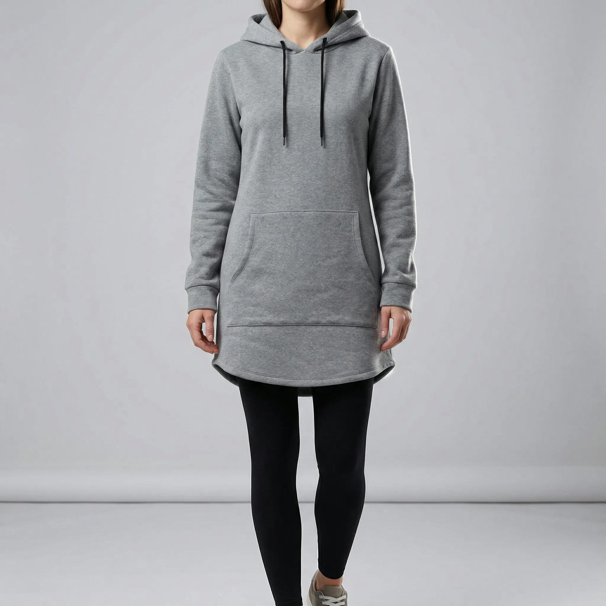 Person wearing a gray hoodie and black leggings on a plain background4