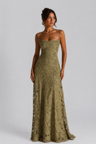 Woman wearing a green lace dress against a gray background