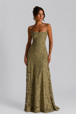 Woman wearing a green lace dress against a gray background