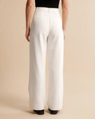 White wide-leg pants worn by a person on a beige background