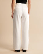 White wide-leg pants worn by a person on a beige background