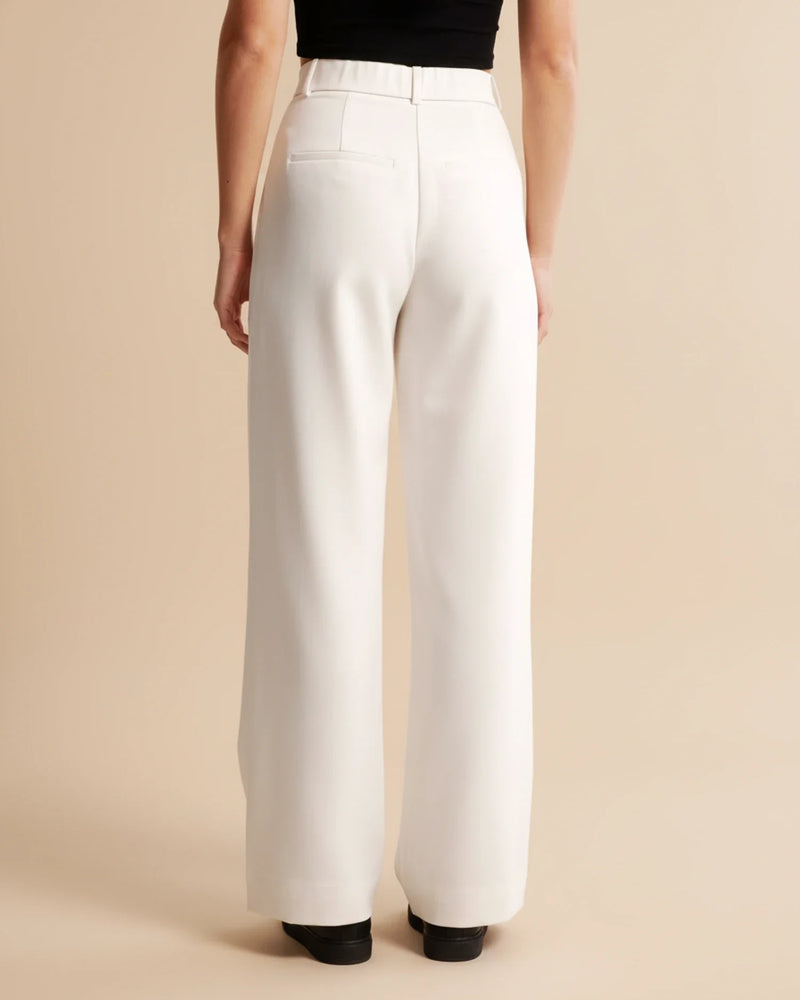 White wide-leg pants worn by a person on a beige background