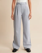 Person wearing light gray wide-leg pants on a beige background