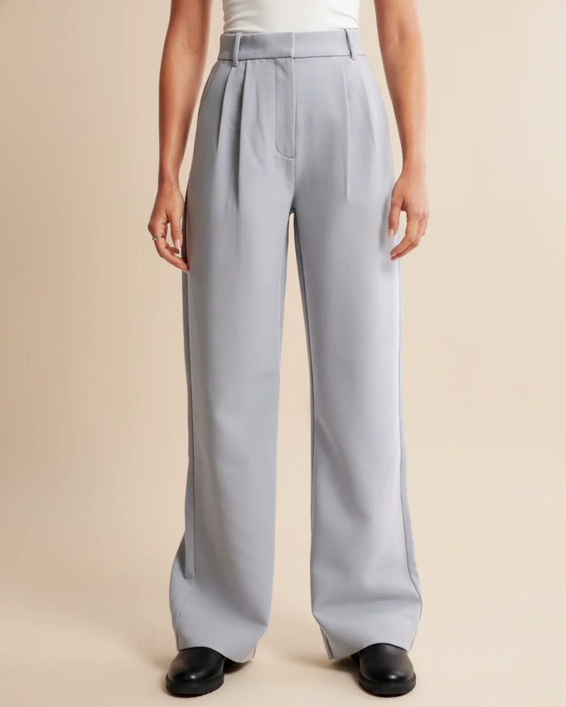 Person wearing light gray wide-leg pants on a beige background