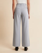 Person wearing light gray wide-leg pants on a beige background