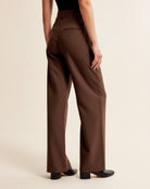 Brown wide-leg pants worn by a person on a beige background