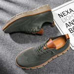 Green casual shoes with brown accents on a gray surface