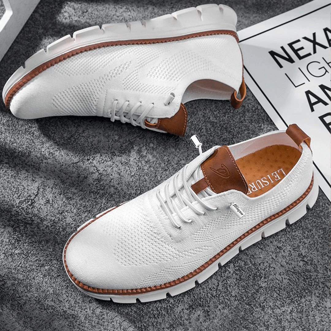 White sneakers with brown accents on a textured surface