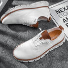 White sneakers with brown accents on a textured surface