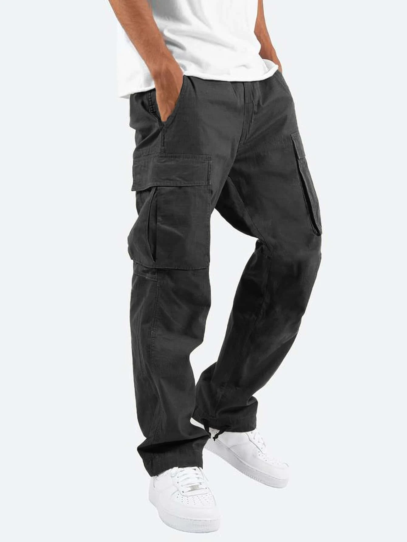 Person wearing dark gray cargo pants on a white background