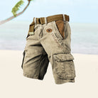 Beige cargo shorts with a brown belt on a blurred natural background