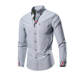 Gray button-up shirt with striped cuffs on a white background