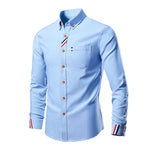Light blue shirt with decorative buttons and trim on a white background