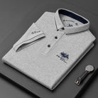 Folded gray polo shirt with brand logo on a dark surface