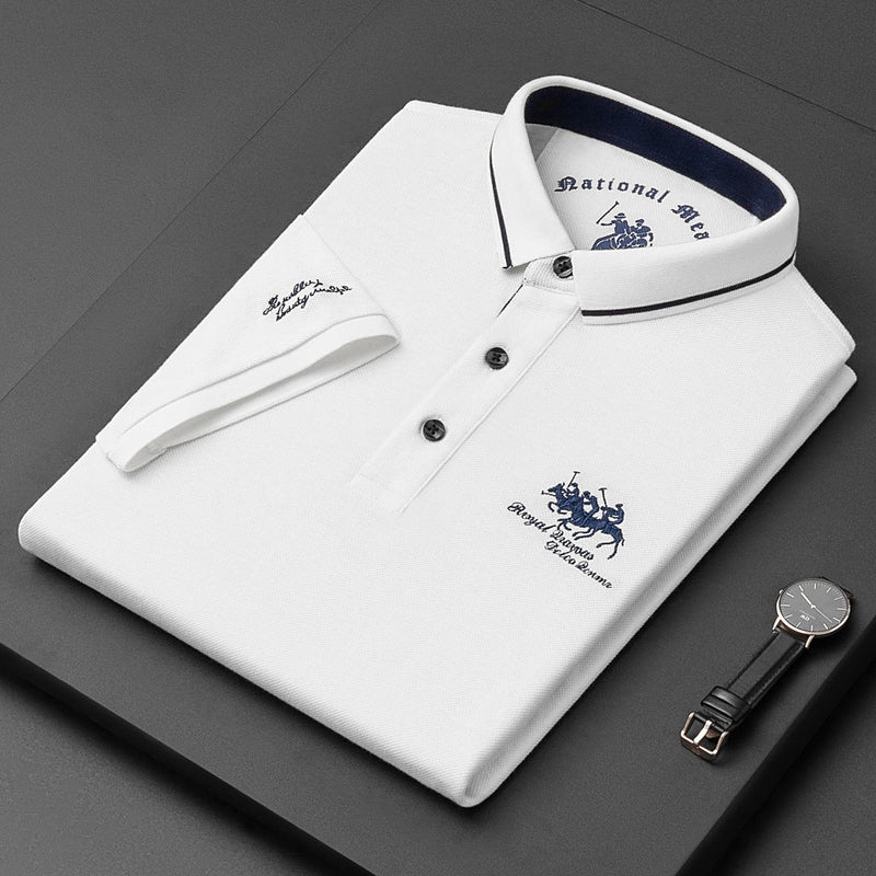 White polo shirt with brand logos on a dark surface, accompanied by a watch.