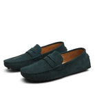 Pair of dark green loafers on a white background