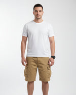 Person wearing beige cargo shorts with a blurred background