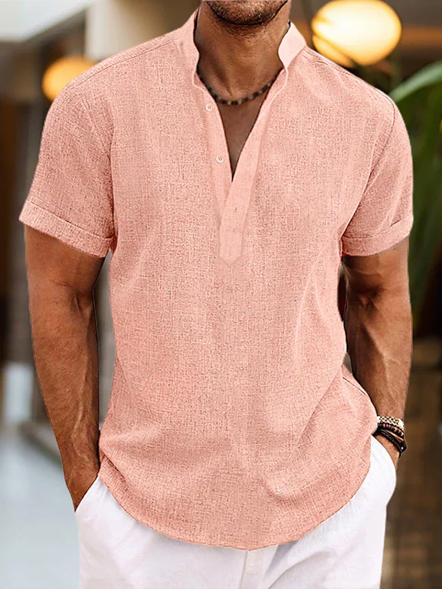 Man wearing a pink short-sleeve shirt with a blurred background