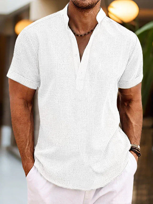 Man wearing a white short-sleeve shirt with a blurred background
