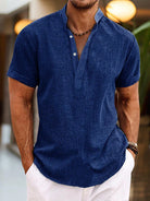 Man wearing a blue short-sleeve shirt with a blurred background
