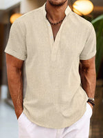 Man wearing a beige short-sleeve shirt with a blurred background