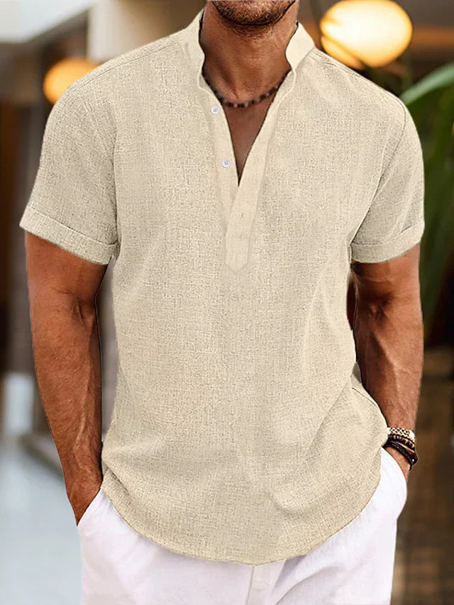 Man wearing a beige short-sleeve shirt with a blurred background