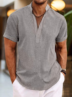 Man wearing a gray short-sleeve shirt with a blurred background