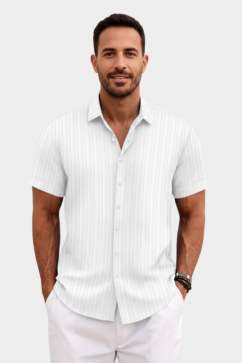 Man wearing a white short-sleeve button-up shirt with vertical stripes on a plain background