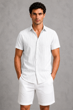 Man wearing a white striped shirt and shorts against a gray background