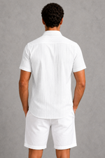 Person wearing a white striped shirt and shorts against a gray background