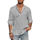 Man wearing a gray long-sleeve shirt and jeans on a white background