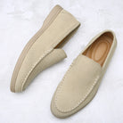 Pair of beige loafers on a light textured surface