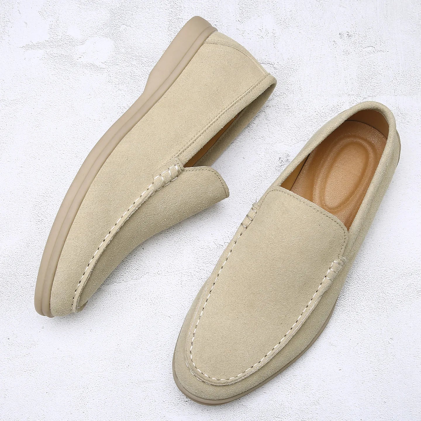 Pair of beige loafers on a light textured surface
