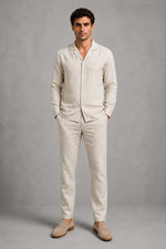 Man wearing a beige linen suit against a gray background