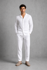 Man wearing a white linen suit against a gray background