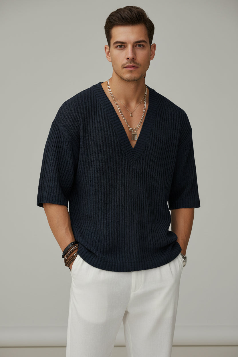Person wearing a dark ribbed sweater with a blurred background