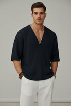 Person wearing a dark ribbed sweater with a blurred background