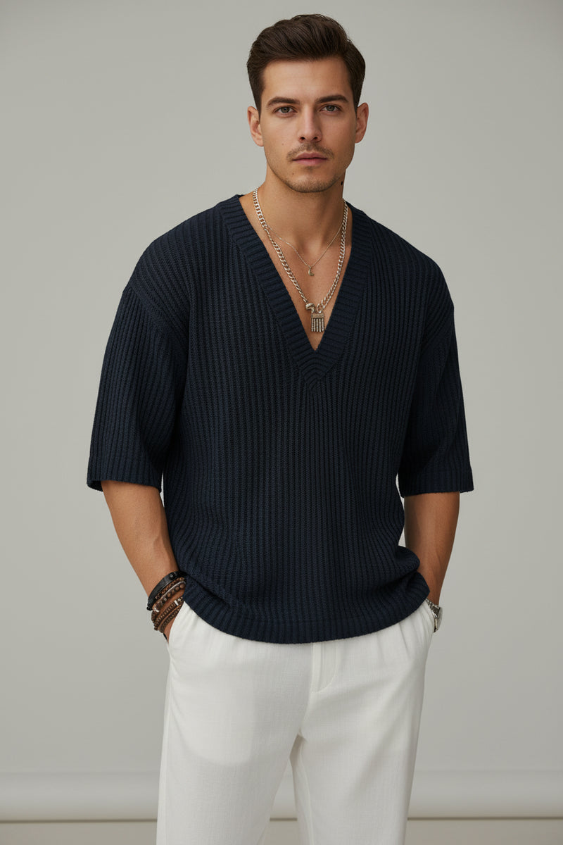 Person wearing a dark ribbed sweater with a blurred background