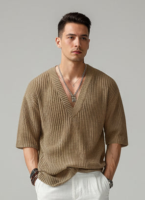 Man wearing a brown knitted sweater with a blurred background