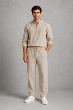 Man wearing a beige outfit with a plain background