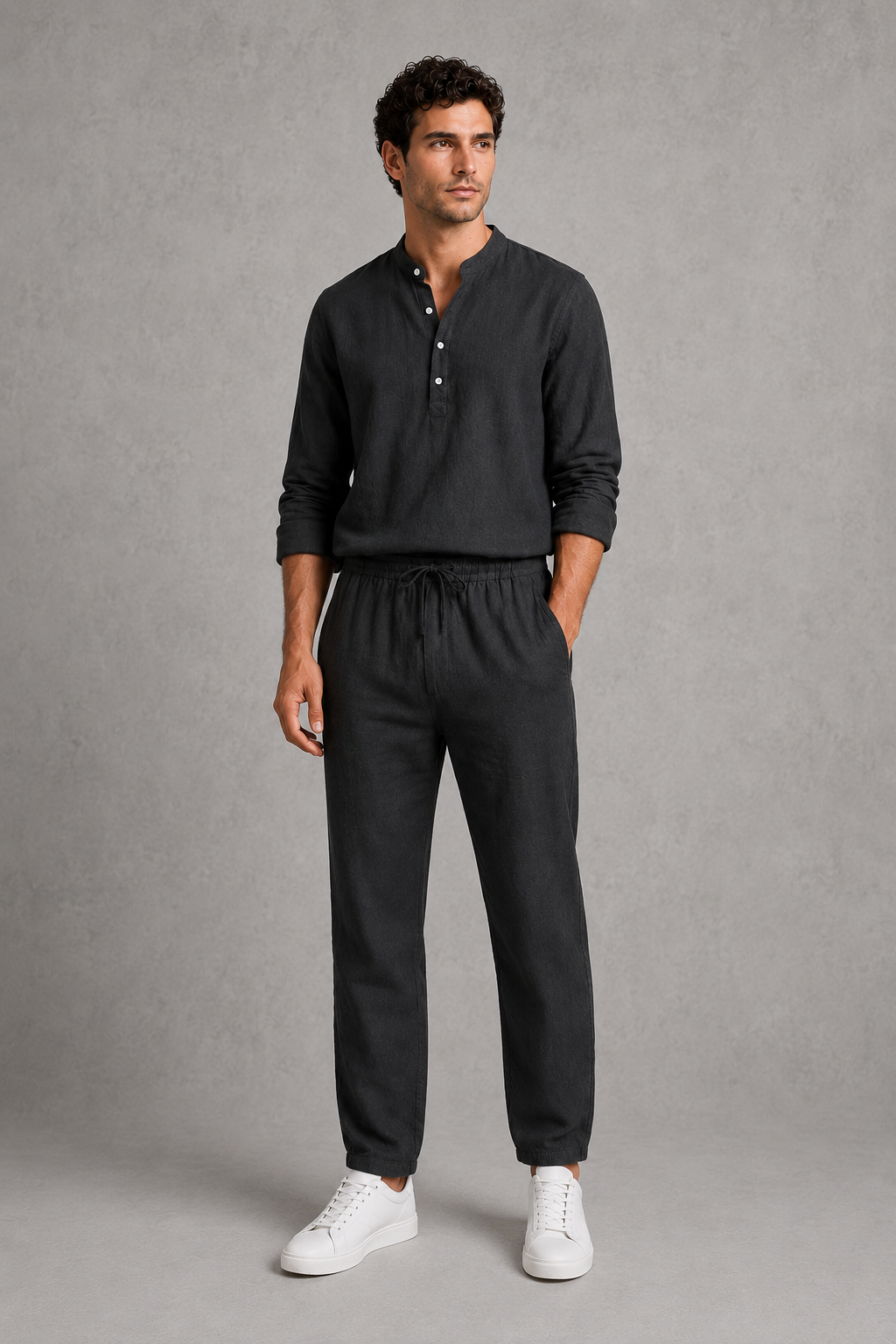 Man wearing a black long-sleeve shirt and pants on a gray background