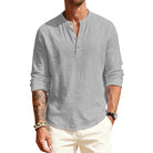 Man wearing a light gray long-sleeve shirt with rolled-up sleeves on a white background