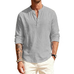Man wearing a light gray long-sleeve shirt with rolled-up sleeves on a white background