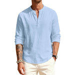 Man wearing a light blue long-sleeve shirt with a brand logo on a white background
