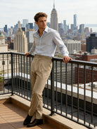 Man standing on a rooftop with a city skyline in the background
