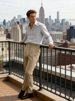 Man standing on a rooftop with a city skyline in the background