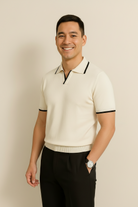 Man wearing a cream-colored polo shirt with black trim on a beige background