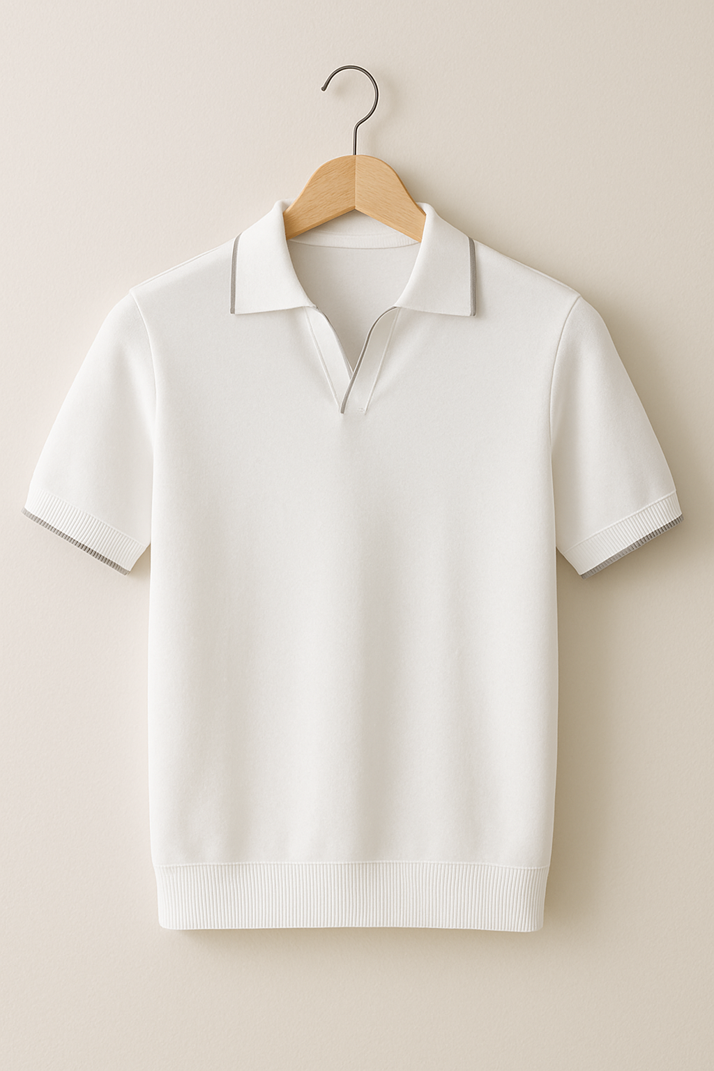 White polo shirt on a wooden hanger against a beige background